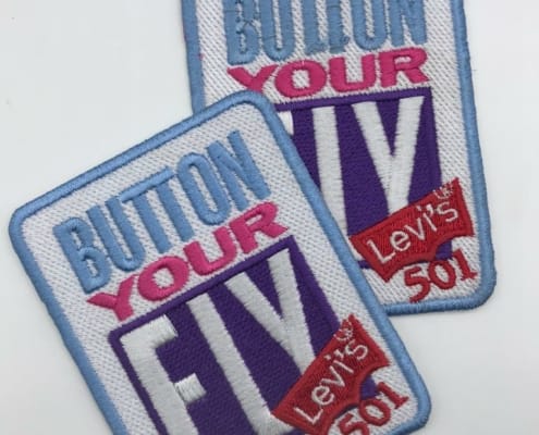 a set of embroidered patch for levis 501 event on white background studio says BUTTON YOUR FLY