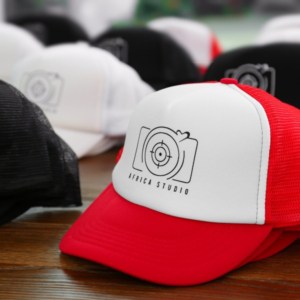 series of hat with custom prints and patches closely captured on floor with red and white on the front